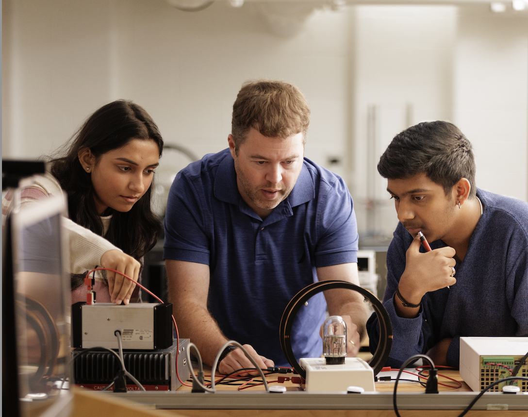 students with professor in physics lab